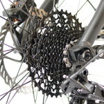 Close up of the rear wheel sprocket of the Eunorau Specter S Electric Mountain bike against a blurred white background.