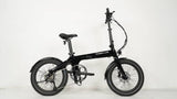 Side on profile of the Carbon Lite Generation 2 folding ebike. This model has Carbon Lite logo on the frame and is in a high gloss paint rather than matte black of the previous bike model. The photo is shot against a white wall.