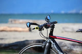 Azur anti-glare blue rearview mirrors fitted on a mountain bike with out of focus seaview background.